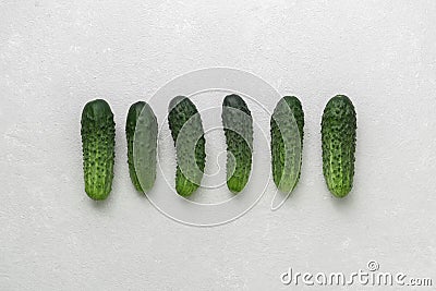 Fresh little ugly green cucumbers on white background. Real organic food. Top view Stock Photo