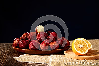Lychees and lemons on a wooden table Stock Photo