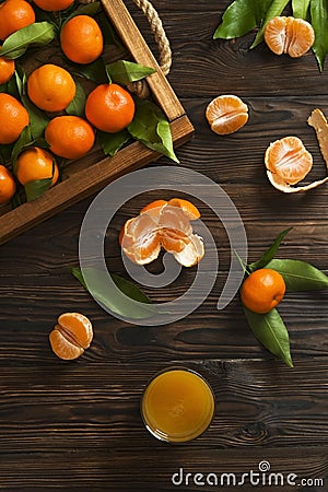 Fresh tangerine oranges on a wooden table. Peeled mandarin. Halves, slices and whole clementines closeup. Stock Photo