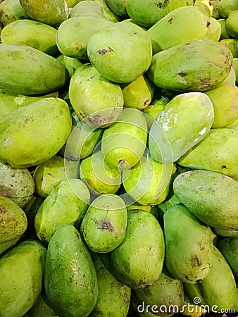 Fresh mangoes in the fruit market, the skin is dominantly green. Stock Photo