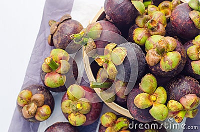 Fresh mangosteen fruits in the basket on paper background Stock Photo