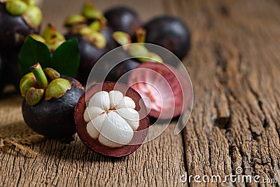 Fresh Mangosteen on old wood baclground. Mangosteen has been known as The Queen of Fruits Stock Photo
