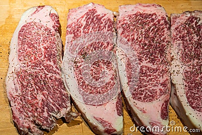 Fresh marbled wagyu beef ribeye steak seasoning with pepper and salt before grill Stock Photo