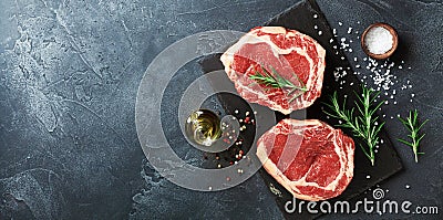 Fresh meat on slate black board top view. Raw beef steak and spices for cooking Stock Photo