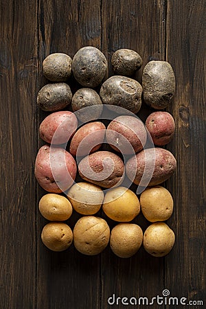 Fresh multi-colored potatoes on a wooden background Stock Photo