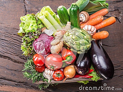 Fresh multi-colored vegetables in wooden crate. Top view. Stock Photo