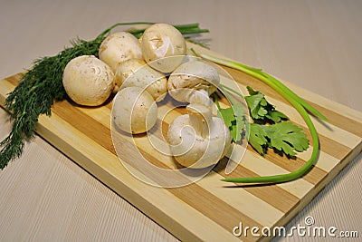 Fresh mushrooms with herbs on a wooden board. Stock Photo