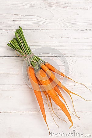 Fresh natural organic carrots bunch light wooden background. Autumn summer harvest concept. Rustic natural style. Stock Photo