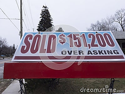 Fresh new sign sold over asking for sale in front of detached house in residential area Stock Photo
