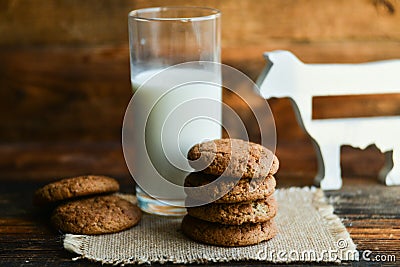 fresh oatmeal cookies and milk on wooden background with spikes of oats Stock Photo