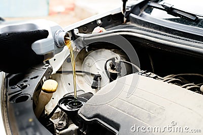 Fresh oil being poured during an oil change to car engine, close Stock Photo