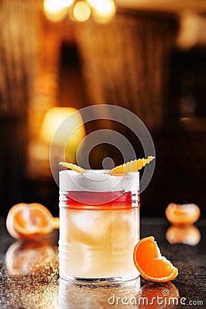 Fresh orange drink with vodka, tangerines and ice in glass on backdrop of the restaurant atmosphere. Summer drinks and cocktails Stock Photo