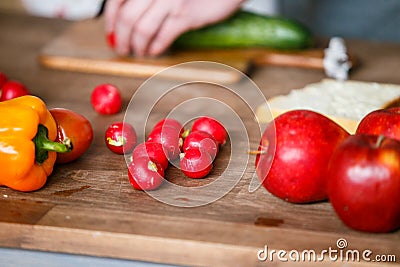 Fresh orange pepper, radish and red apples on the wooden board Stock Photo