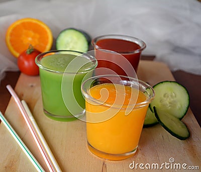 Fresh orange,tomato and cucumber smoothie on a glass. Stock Photo