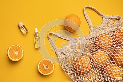 Fresh oranges in a eco bag. Cutted citrus fruit for healthly food. A bottle of essential oils. Stock Photo