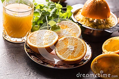 Fresh oranges juicer juice tropical fruits and herbs on concrete board Stock Photo