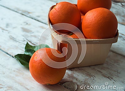 Fresh organic Oranges in basket on wooden table. Stock Photo