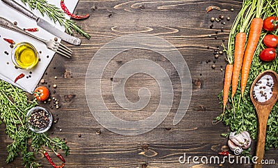 Fresh organic vegetables and spoons on rustic wooden background, top view, border. Healthy food or vegetarian cooking concept Stock Photo