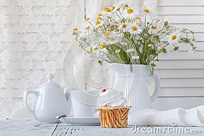 Fresh Oxeye Daisies on table in white Pitcher in interior Stock Photo