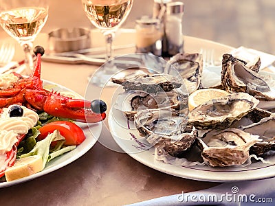 Fresh oysters served on a table in summer restaurant with lemon and lobster garnished with freshly made mayonnaise Stock Photo