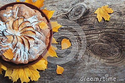 Fresh pastry apple pie charlotte on wooden table background decorated with yellow autumn leaves. Fall Food Cook Cuisine Homemade Stock Photo