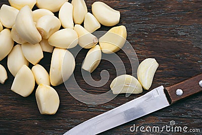 Fresh Peeled Garlic Cloves on old wooden background Stock Photo