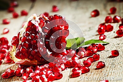 Fresh peeled pomegranates with ruby red beans on old wooden table, selective focus Stock Photo