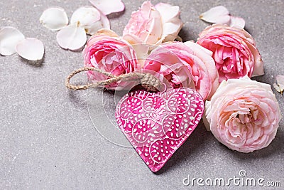 Fresh pink roses and decorative pink heart on grey slate back Stock Photo