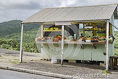 Fresh harvested fruits and vegetables by green grocer, Barbados. Fruit stall in front of tropical rainforest in Caribbean Sea. Editorial Stock Photo