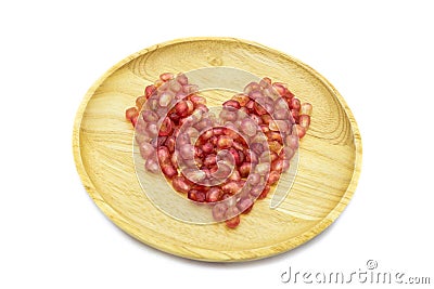 Fresh pomegranate heart shape on wooden plate isolated Stock Photo