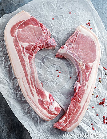 Fresh Pork middle cut ready to cook served with red pepper on roasting paper. Stock Photo