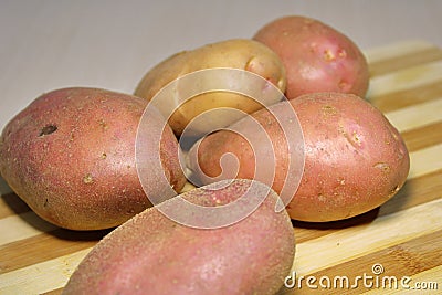 Fresh potatoes on a wooden board. Stock Photo