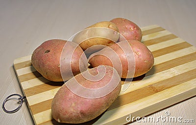 Fresh potatoes on a wooden board. Stock Photo