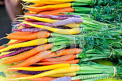 Fresh purple and orange carrots on display at the farmers market. Stock Photo