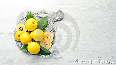 Fresh quince fruits on a wooden board. Top view. Stock Photo