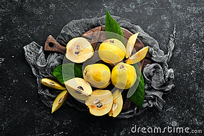 Fresh quince fruits on a wooden board. Top view. Stock Photo