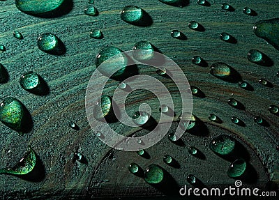 Fresh rain water droplets on green wood table closeup view Stock Photo