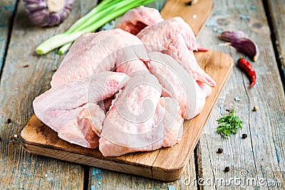Fresh raw chicken wings with garlic, onion and peppers on a cutting board Stock Photo