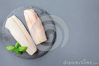 Fresh raw cod fillet with basil on stone plate, horizontal, copy Stock Photo