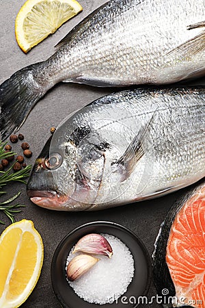 Fresh raw dorado fish, spices and lemon slices on grey table, flat lay Stock Photo