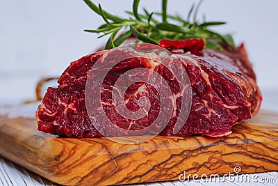 Fresh raw flank steak on the very nice rustikal wooden plate. White background with copy space for text Stock Photo