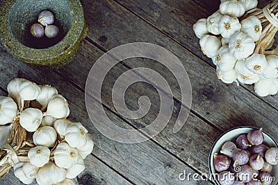 Fresh raw garlic bundle on cutting board, traditional mortar, copy space, kitchen raw ingredient concept Stock Photo