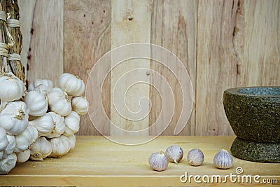 Fresh raw garlic bundle on cutting board, traditional mortar, copy space, kitchen raw ingredient concept Stock Photo