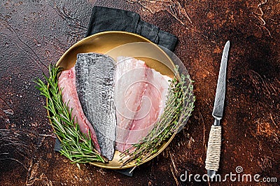 Fresh Raw Gilthead Sea bream fish fillets ready for cooking. Dark background. Top view Stock Photo