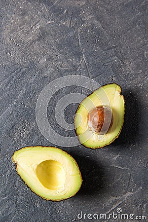 Fresh raw halfs of avocado on a dark stone table, healthy eating concept, top view with copy space Stock Photo