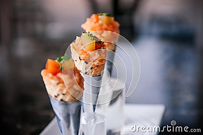 Fresh raw juicy Salmon Tartare with tomato in mini waffle cones modern creative cuisine Stock Photo