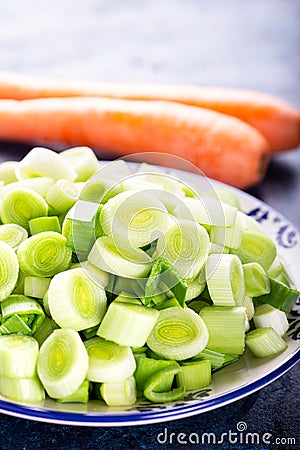 Fresh raw leek slice in a bowl with carrots. washed sliced ready-to-cook leeks Stock Photo