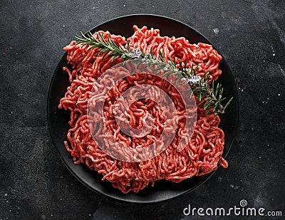 Fresh Raw mince, Minced beef, ground meat with herbs and spices on black plate Stock Photo