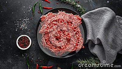Fresh Raw mince, Minced beef, ground meat with herbs and spices on black plate Stock Photo