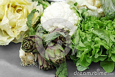 Fresh raw organic bio uncooked vegetables for sale at farmers market. Artichoke, lettuce, cauliflower at market, stock photo.Vegan Stock Photo